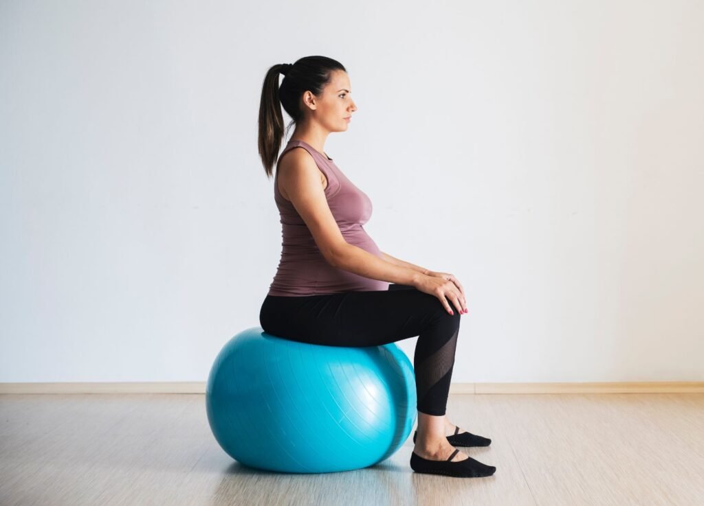 2 Embarazada sentada en pelota de yoga durante clase de esferodinamia